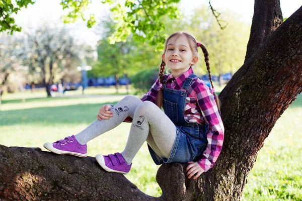 Chica está sentada en el árbol —  Fotos de Stock