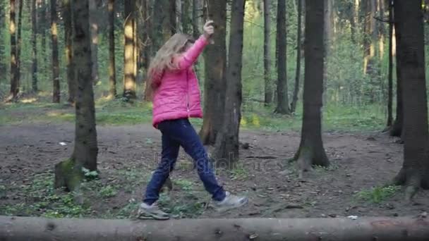 Küçük kız kütük üstünde yürüyor — Stok video