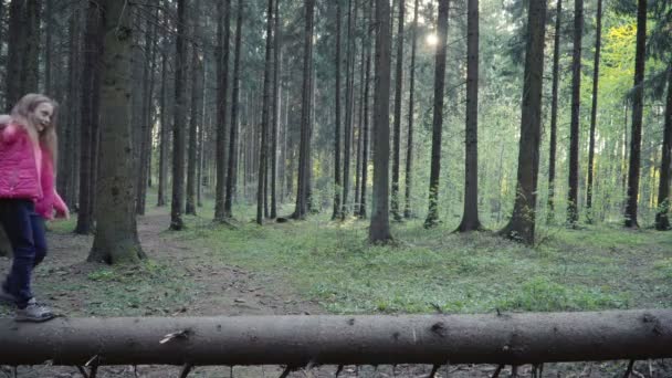 Niños está caminando sobre el tronco en el bosque — Vídeos de Stock