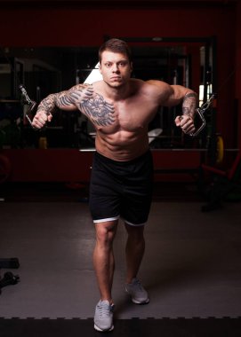 Vücut geliştirmeci adam crossover egzersiz gerçekleştirme