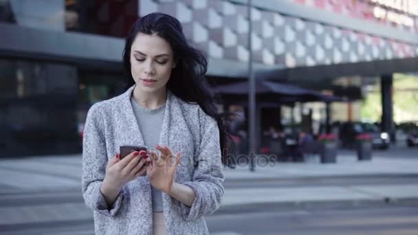 Mujer usando el teléfono inteligente en la ciudad — Vídeo de stock