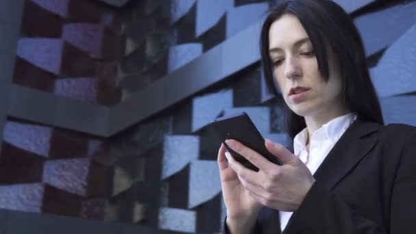 Mujer de negocios utiliza un teléfono inteligente — Vídeo de stock