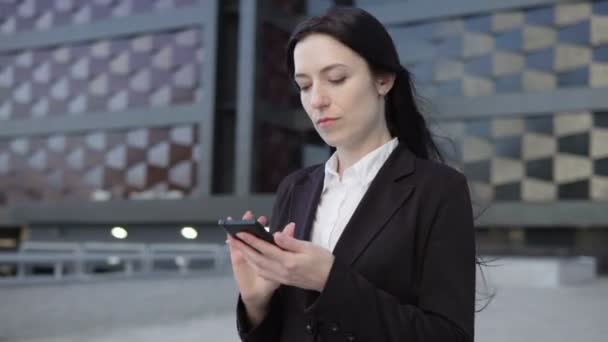 Mujer de negocios utiliza un teléfono inteligente — Vídeo de stock