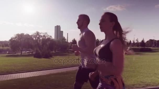 Hombre y mujer corriendo en el parque de la ciudad — Vídeo de stock