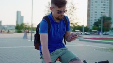 adam bir bisiklet sürmek ve bir akıllı telefon kullanır