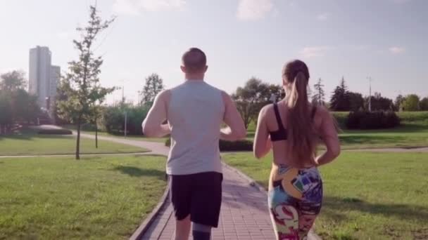 Uomo e donna che corrono nel parco cittadino — Video Stock