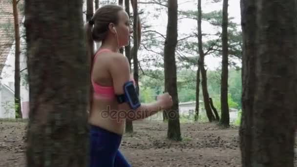 Mujer corriendo en el bosque — Vídeo de stock