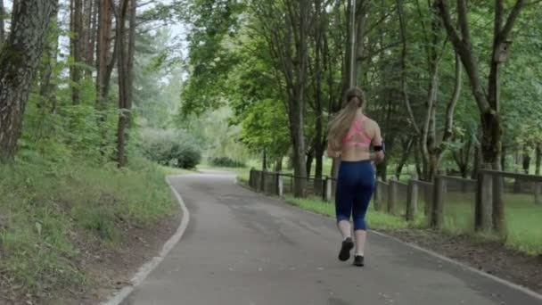 Frau läuft im Park — Stockvideo