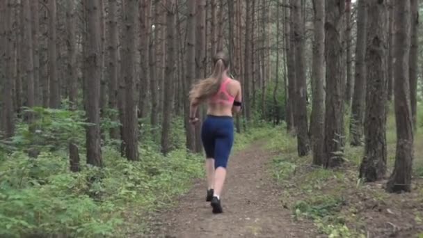 Женщина бежит в лесу — стоковое видео