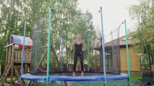 Kvinnan hoppar på en studsmatta — Stockvideo