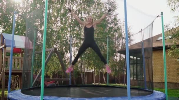 Женщина прыгает на батуте — стоковое видео