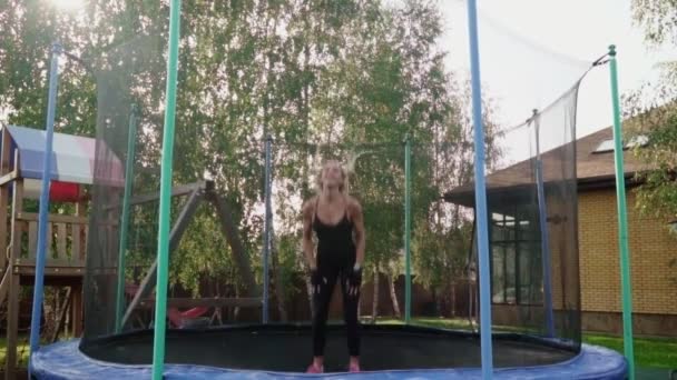 Woman jumping on a trampoline — Stock Video