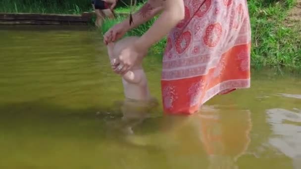 Mor badar barnet i dammen — Stockvideo