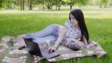 parkta dizüstü kullanan kadın