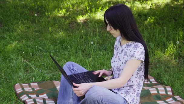 Mujer usando portátil en el parque — Vídeos de Stock