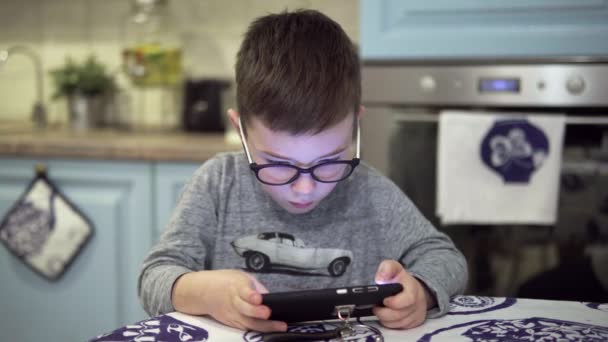 Boy is playing on the smartphone — Stock Video