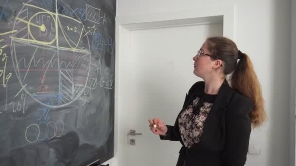 Vrouw schrijft op een schoolbord — Stockvideo