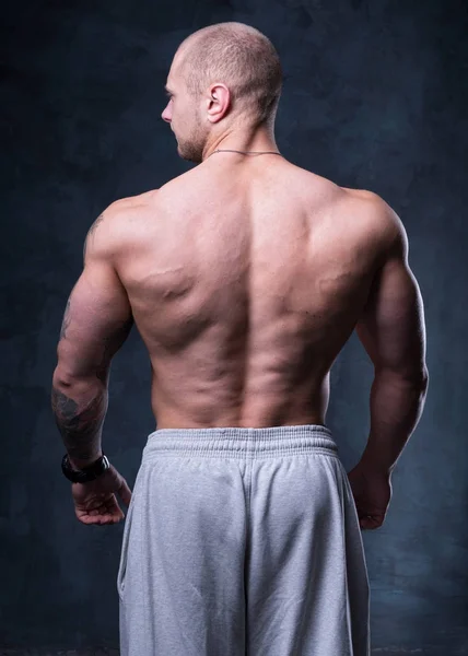 Man bodybuilder demonstrates muscles — Stock Photo, Image