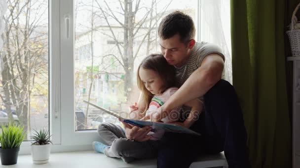 Vater und Tochter lesen ein Buch — Stockvideo