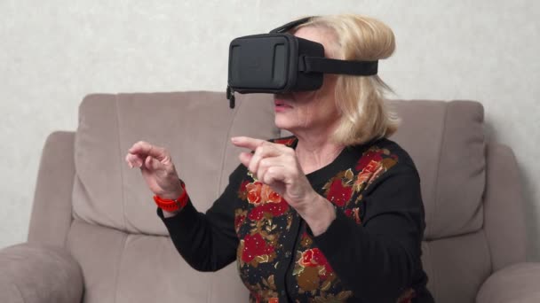 Bejaarde vrouw met behulp van vr-bril — Stockvideo