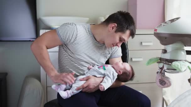 Батько тримає новонароджену дитину на руках — стокове відео