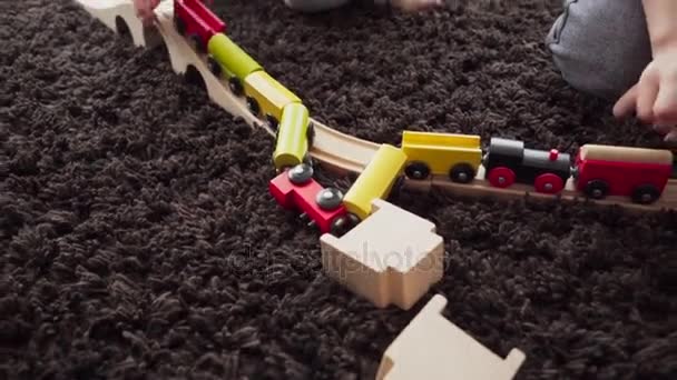 Los niños construyen locomotora de juguete modelo madera — Vídeos de Stock