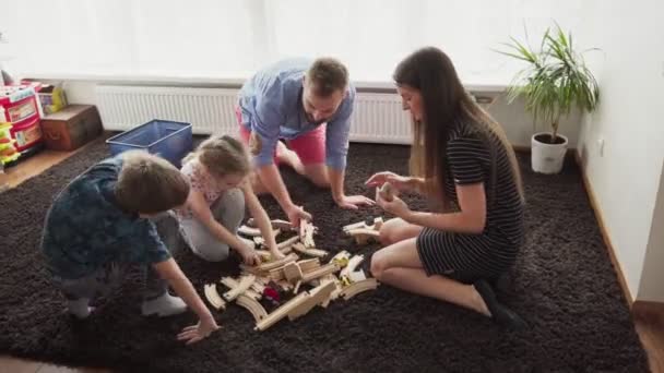 Дети и родители играют вместе на полу — стоковое видео