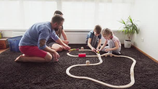 Familia con niños juegan juntos en el suelo en una habitación — Vídeos de Stock