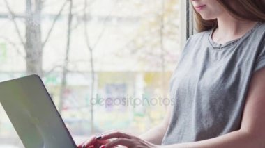 genç kadın evde bir dizüstü bilgisayar kullanarak