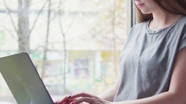 Genç kadın evde bir dizüstü bilgisayar kullanarak — Stok video