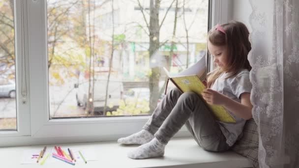 Klein meisje dat een boek leest — Stockvideo