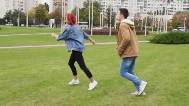 Uomo che insegue una donna in un parco cittadino — Video Stock