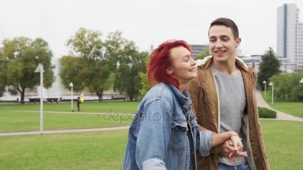 Lycklig man och kvinna promenader och omfamna i en stadspark — Stockvideo