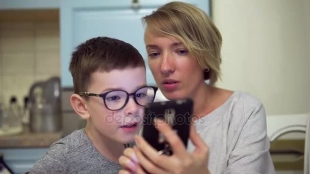 Madre e hijo asombrados mirando la pantalla del teléfono inteligente — Vídeo de stock