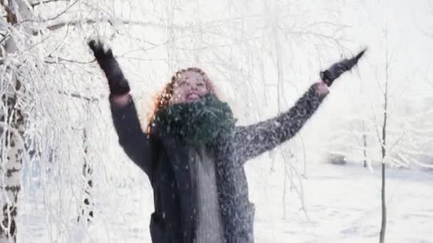 Mujer joven vomitar un puñado de nieve y risas, día de invierno soleado — Vídeo de stock