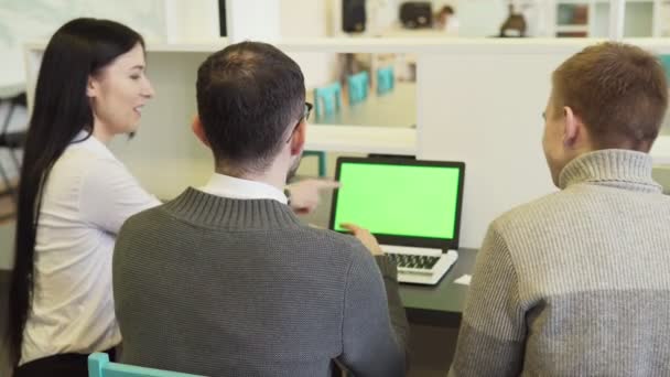 Groep van mensen uit het bedrijfsleven bespreken iets op een groen scherm laptop — Stockvideo