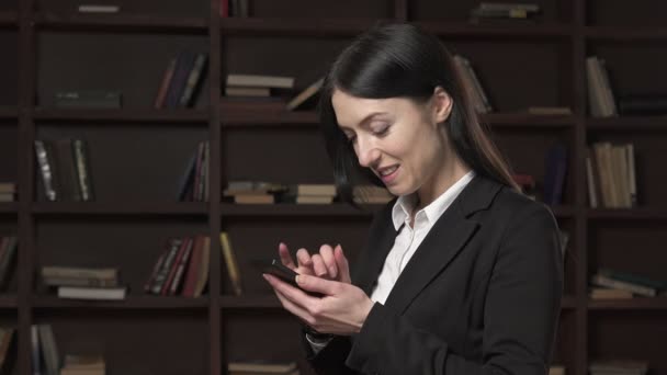 Γυναίκα ευτυχισμένη επιχειρήσεων χρησιμοποιώντας ένα smartphone — Αρχείο Βίντεο