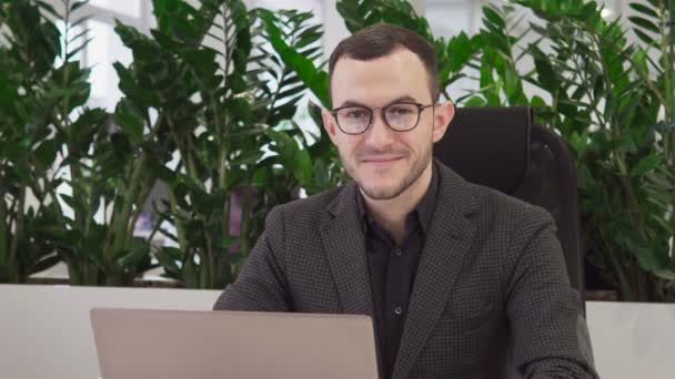 Boldog üzletember keresi a kamera, és mosolyogva — Stock videók