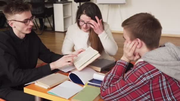 Estudantes estudando juntos e lendo um livro — Vídeo de Stock