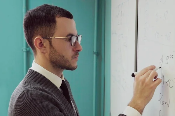 Mann mit Brille schreibt auf Whiteboard — Stockfoto