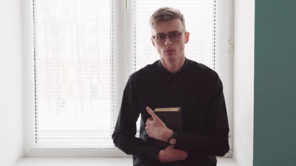 Religiösa barnman innehar en bibel och tittar på kameran — Stockvideo