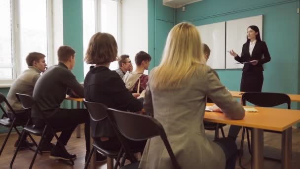 Studenten en een leraar vrouw tijdens een les in een universiteit klasse — Stockvideo