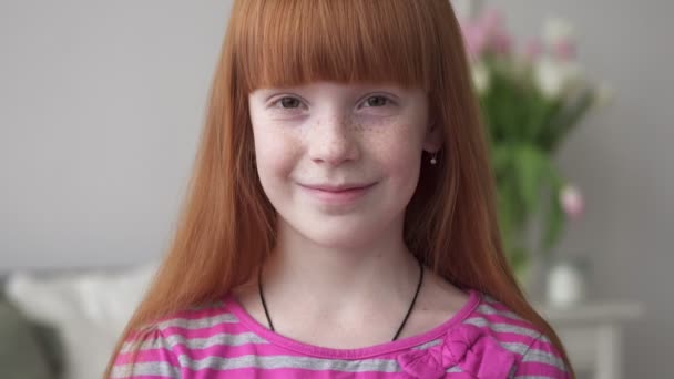 Little happy ginger girl with freckles smiling in a white room — Stock Video