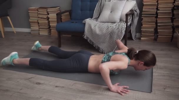 Γυναίκα καταλληλότητας, κάνει ασκήσεις για τους ραχιαίους μυς σε χαλί στο σπίτι — Αρχείο Βίντεο