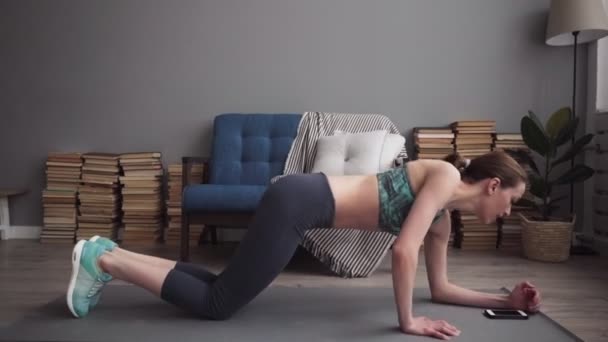 Женщина делает упражнения на коврике дома — стоковое видео