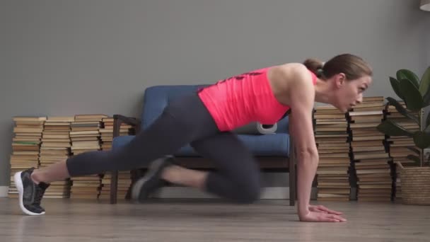 Mujer de fitness haciendo escalador de montaña corriendo entrenamiento en casa — Vídeo de stock