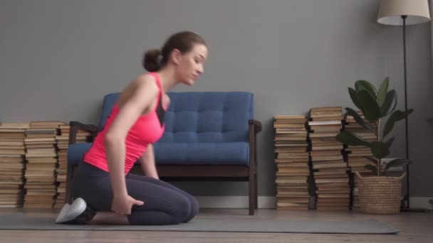 Молода фітнес-леді робить розтягування в дитячій позі на килимку вдома — стокове відео