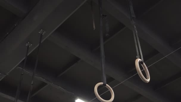 Hombre atleta haciendo anillos músculo ups ejercicio en el gimnasio — Vídeos de Stock