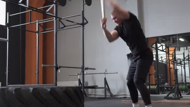 Athlète masculin faisant de l'exercice de balançoire de marteau de traîneau dans la salle de gym cross fit — Video
