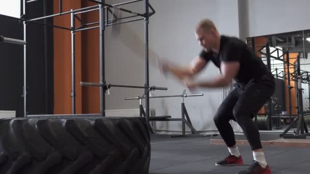 Fitness man voorhamer schommel oefening in de sportschool doet — Stockvideo